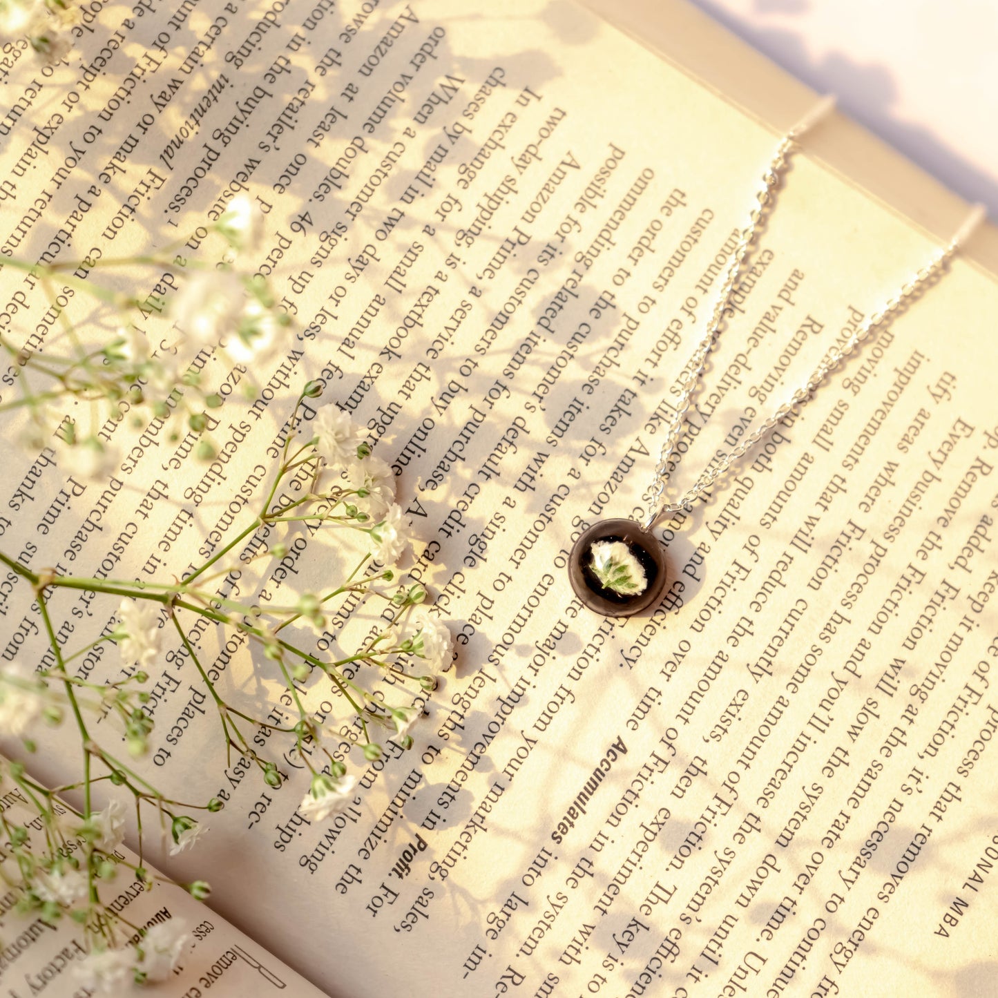 A collection of handmade resin art pendants, showcasing intricate floral designs preserved in clear resin, attached to delicate necklaces.