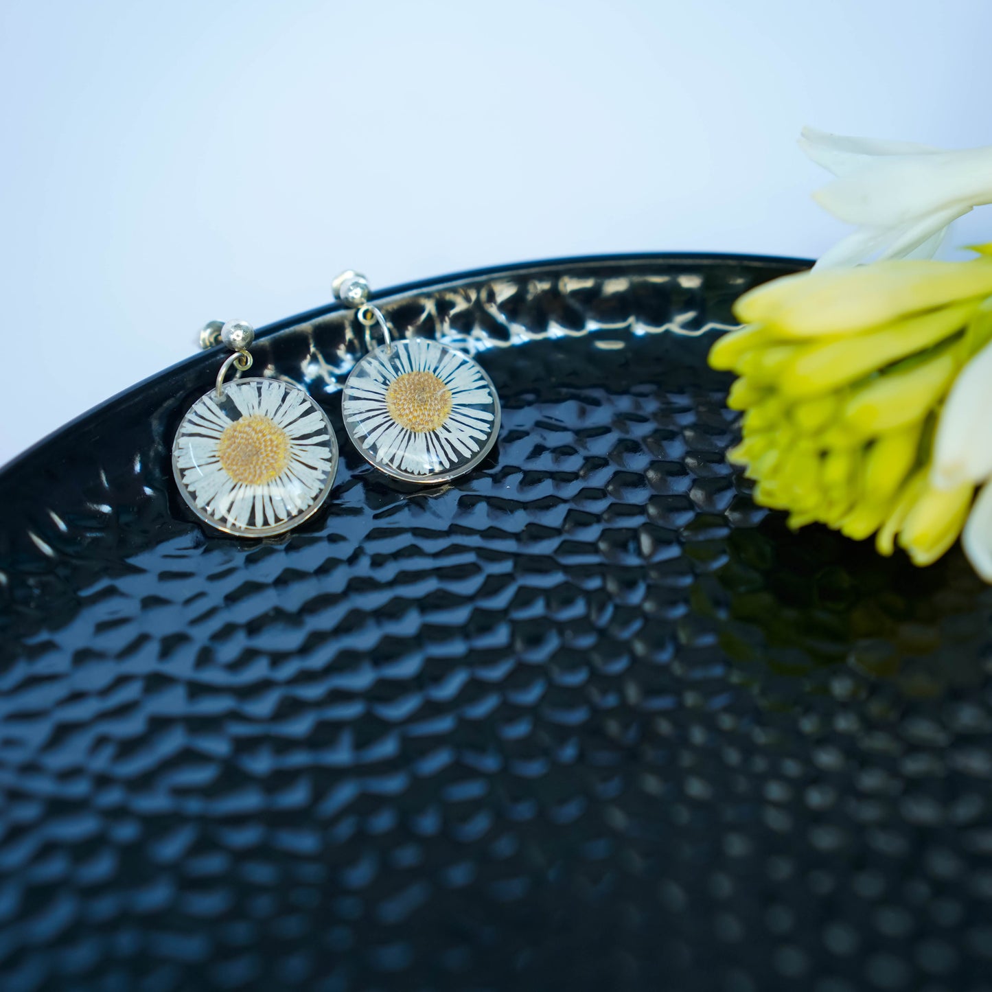 Pair of Erstella flower earrings styled with a minimal outfit for everyday wear.