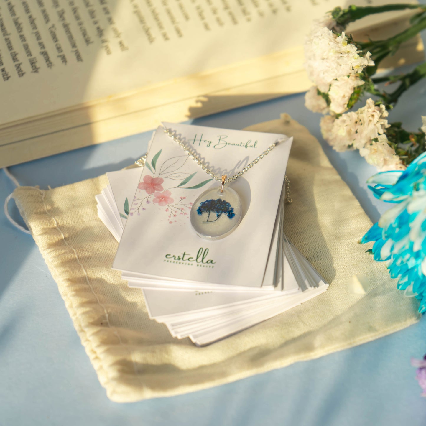 A collection of handmade resin art pendants, showcasing intricate floral designs preserved in clear resin, attached to delicate necklaces.