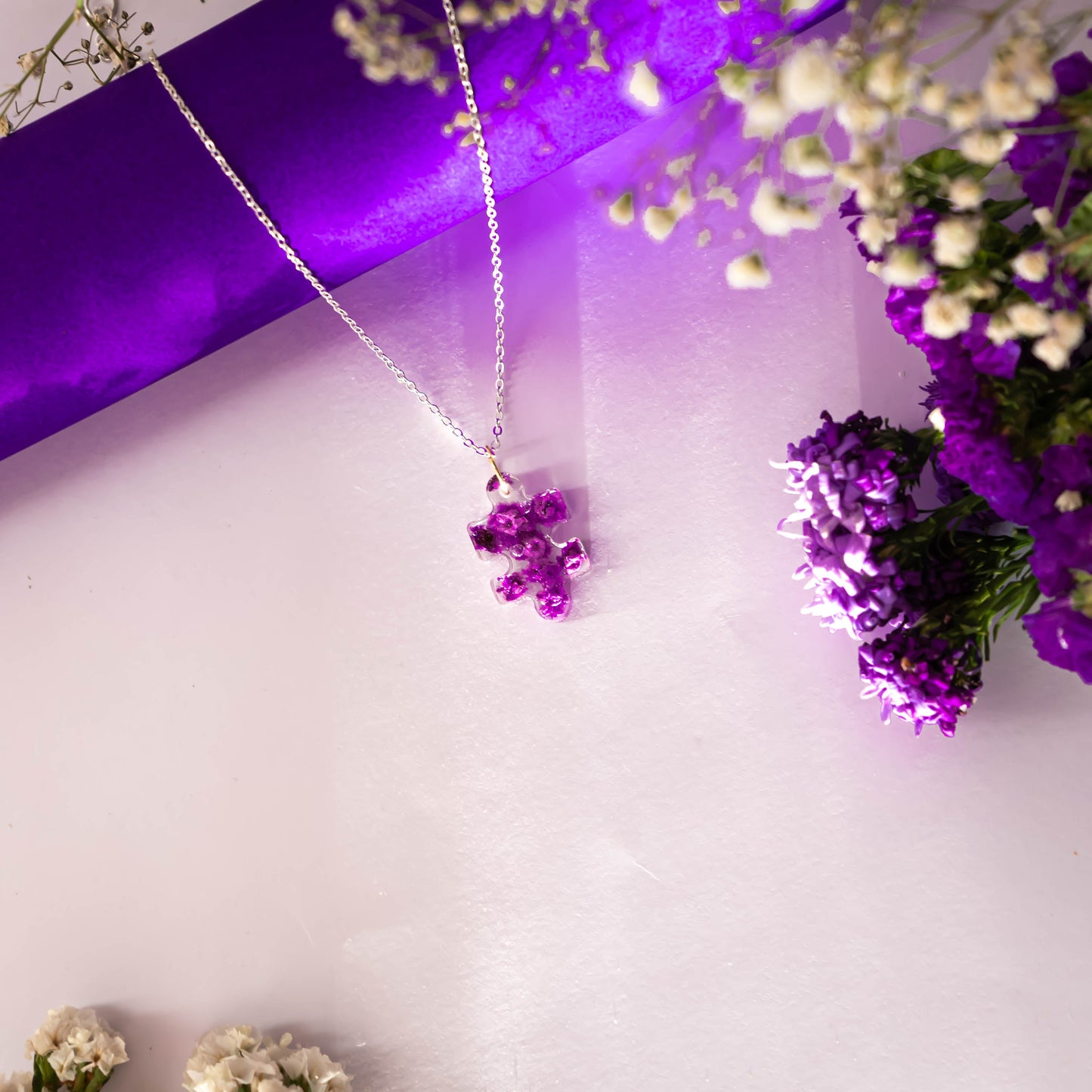 A collection of handmade resin art pendants, showcasing intricate floral designs preserved in clear resin, attached to delicate necklaces.