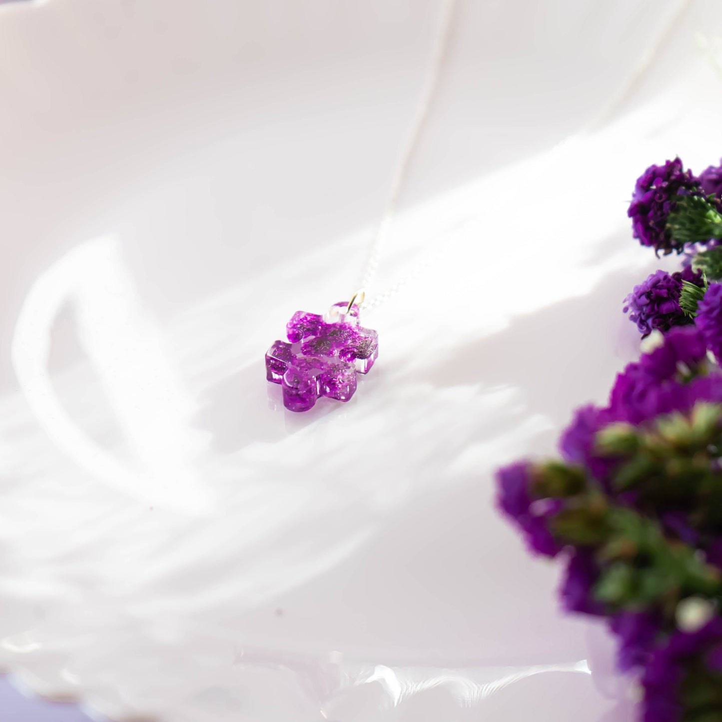 A collection of handmade resin art pendants, showcasing intricate floral designs preserved in clear resin, attached to delicate necklaces.