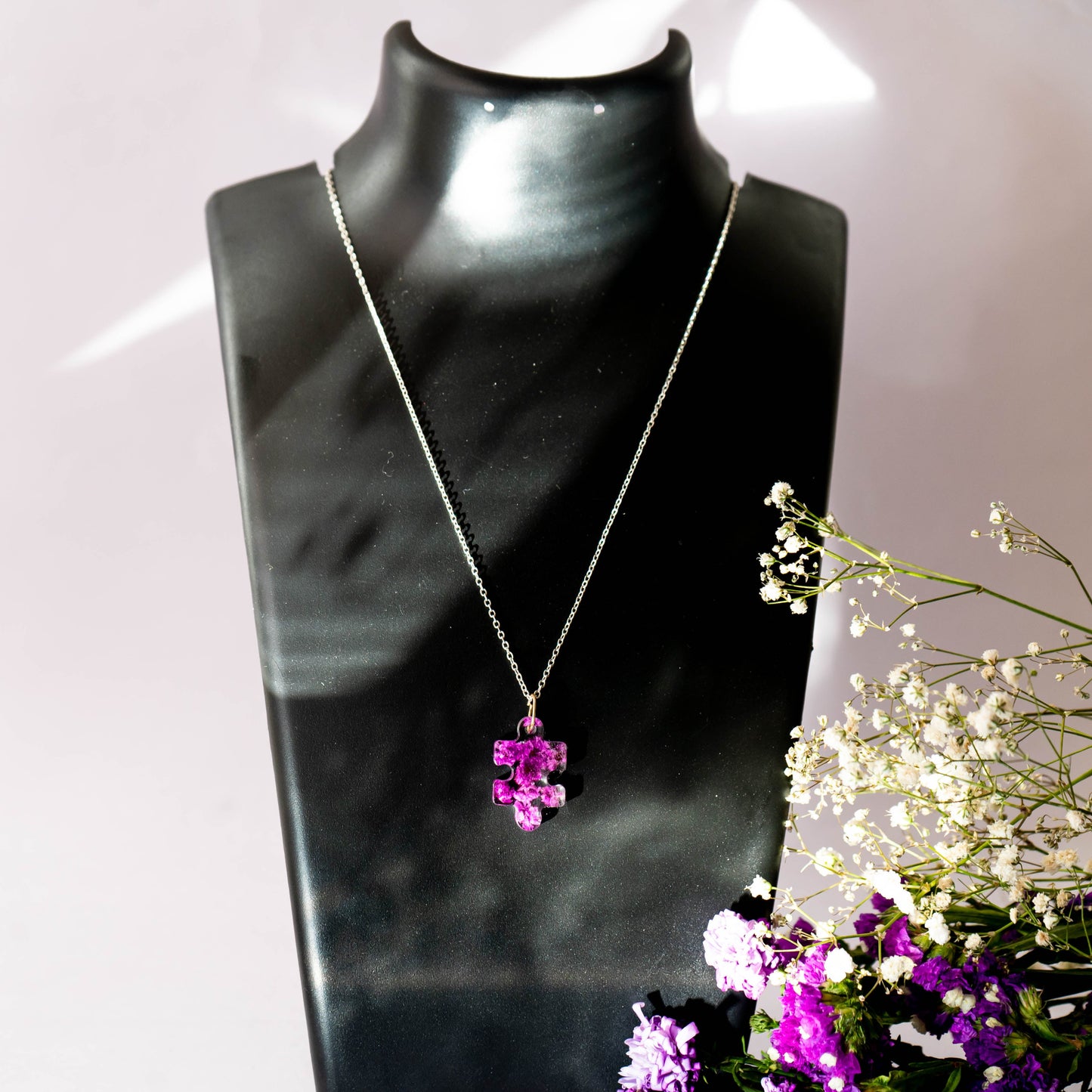 A collection of handmade resin art pendants, showcasing intricate floral designs preserved in clear resin, attached to delicate necklaces.