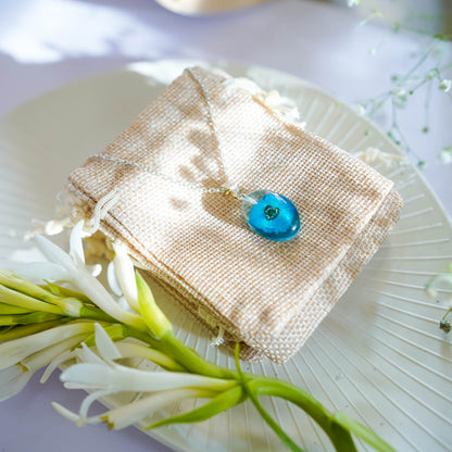 A collection of handmade resin art pendants, showcasing intricate floral designs preserved in clear resin, attached to delicate necklaces.