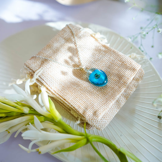 A collection of handmade resin art pendants, showcasing intricate floral designs preserved in clear resin, attached to delicate necklaces.