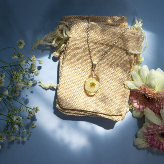 A collection of handmade resin art pendants, showcasing intricate floral designs preserved in clear resin, attached to delicate necklaces.