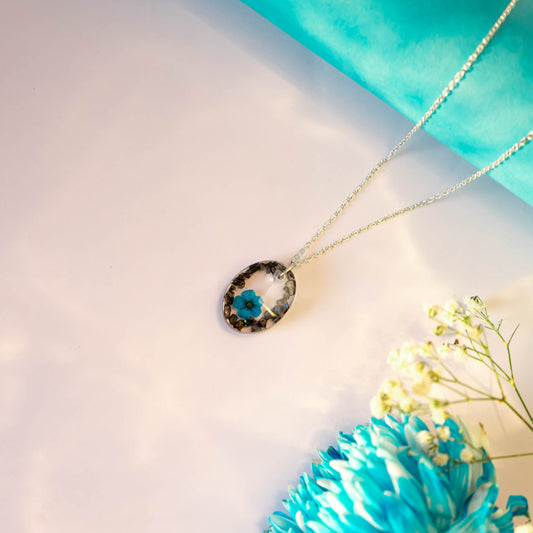 A collection of handmade resin art pendants, showcasing intricate floral designs preserved in clear resin, attached to delicate necklaces.