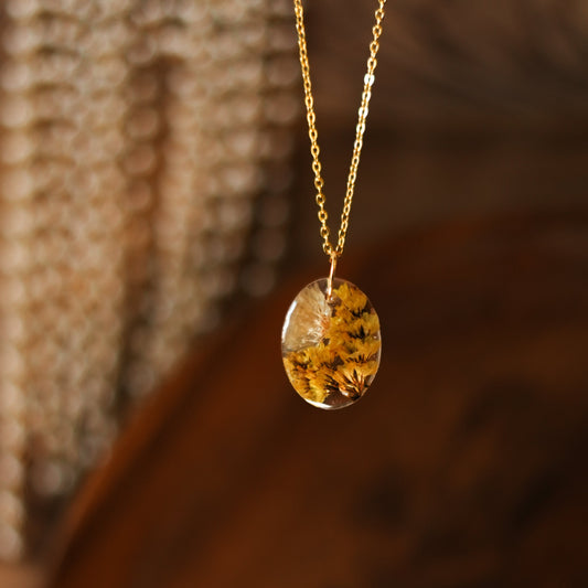 A collection of handmade resin art pendants, showcasing intricate floral designs preserved in clear resin, attached to delicate necklaces.