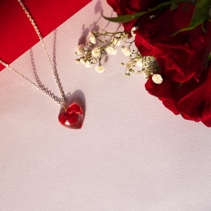 A collection of handmade resin art pendants, showcasing intricate floral designs preserved in clear resin, attached to delicate necklaces.