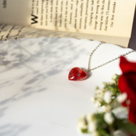 A collection of handmade resin art pendants, showcasing intricate floral designs preserved in clear resin, attached to delicate necklaces.