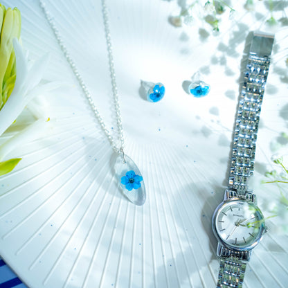 A collection of handmade resin art pendants, showcasing intricate floral designs preserved in clear resin, attached to delicate necklaces.