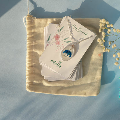 A collection of handmade resin art pendants, showcasing intricate floral designs preserved in clear resin, attached to delicate necklaces.