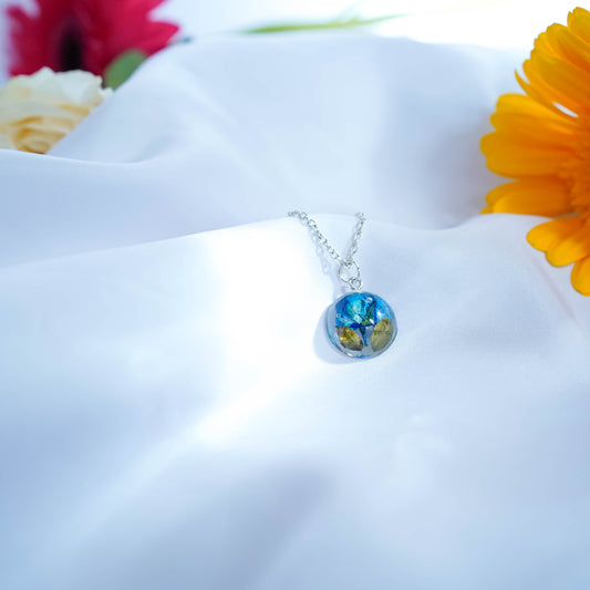 A collection of handmade resin art pendants, showcasing intricate floral designs preserved in clear resin, attached to delicate necklaces.