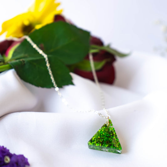 A collection of handmade resin art pendants, showcasing intricate floral designs preserved in clear resin, attached to delicate necklaces.