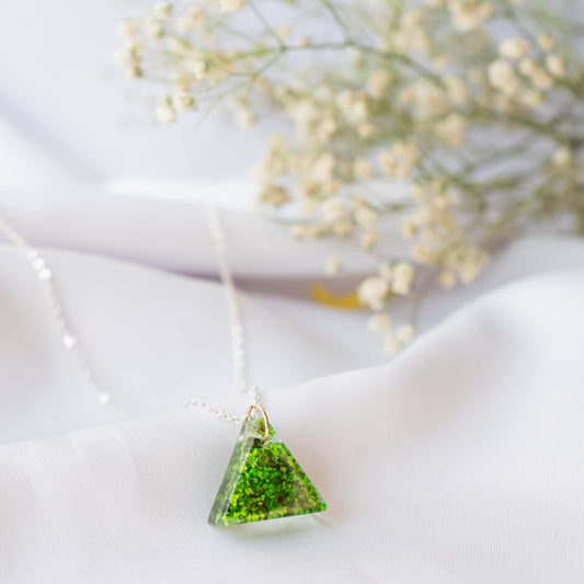 A collection of handmade resin art pendants, showcasing intricate floral designs preserved in clear resin, attached to delicate necklaces.