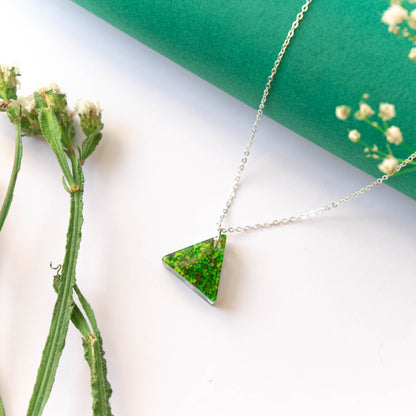 A collection of handmade resin art pendants, showcasing intricate floral designs preserved in clear resin, attached to delicate necklaces.