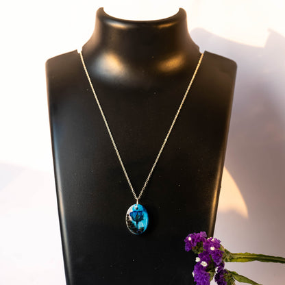 A collection of handmade resin art pendants, showcasing intricate floral designs preserved in clear resin, attached to delicate necklaces.