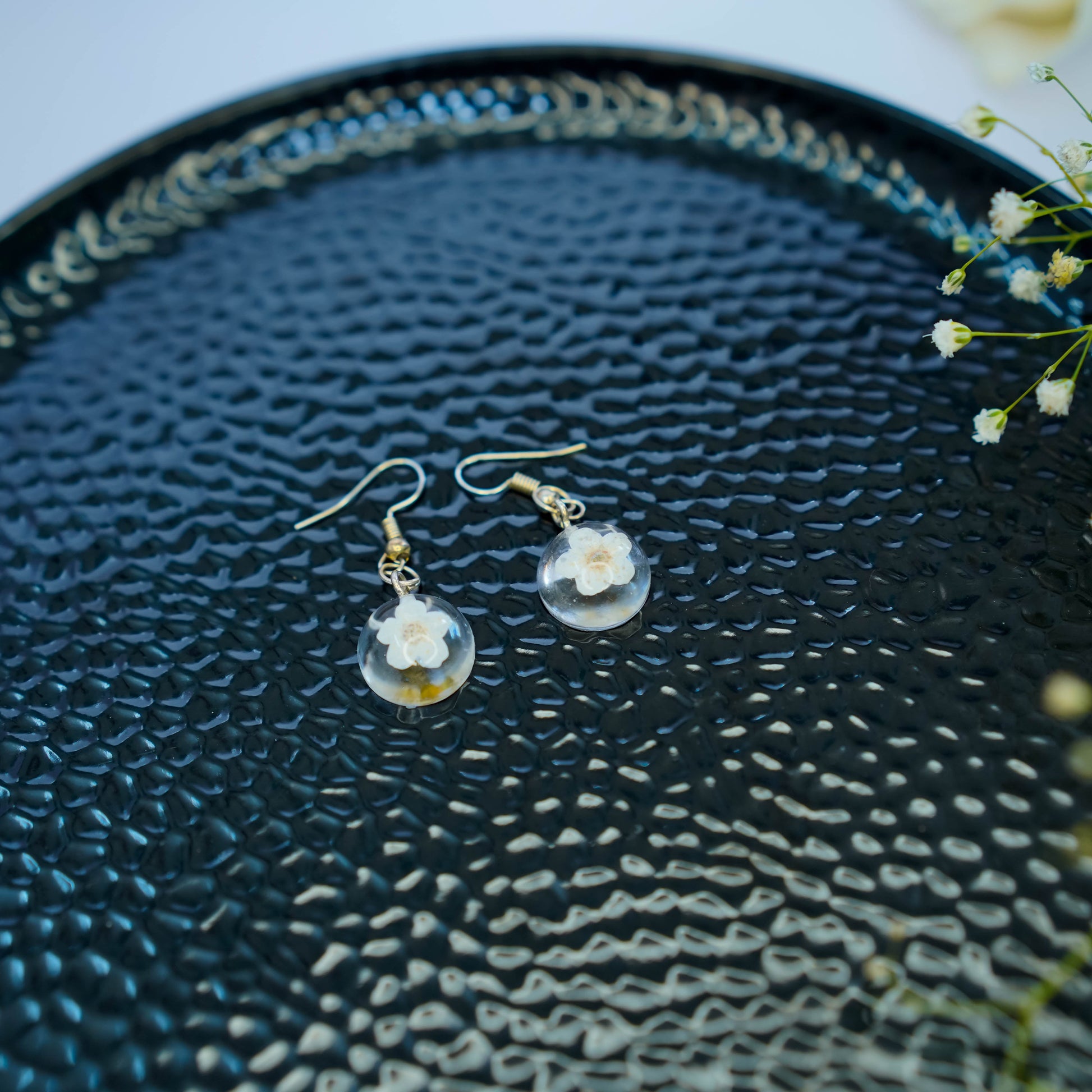 Pair of Erstella flower earrings styled with a minimal outfit for everyday wear.