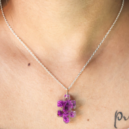 A collection of handmade resin art pendants, showcasing intricate floral designs preserved in clear resin, attached to delicate necklaces.
